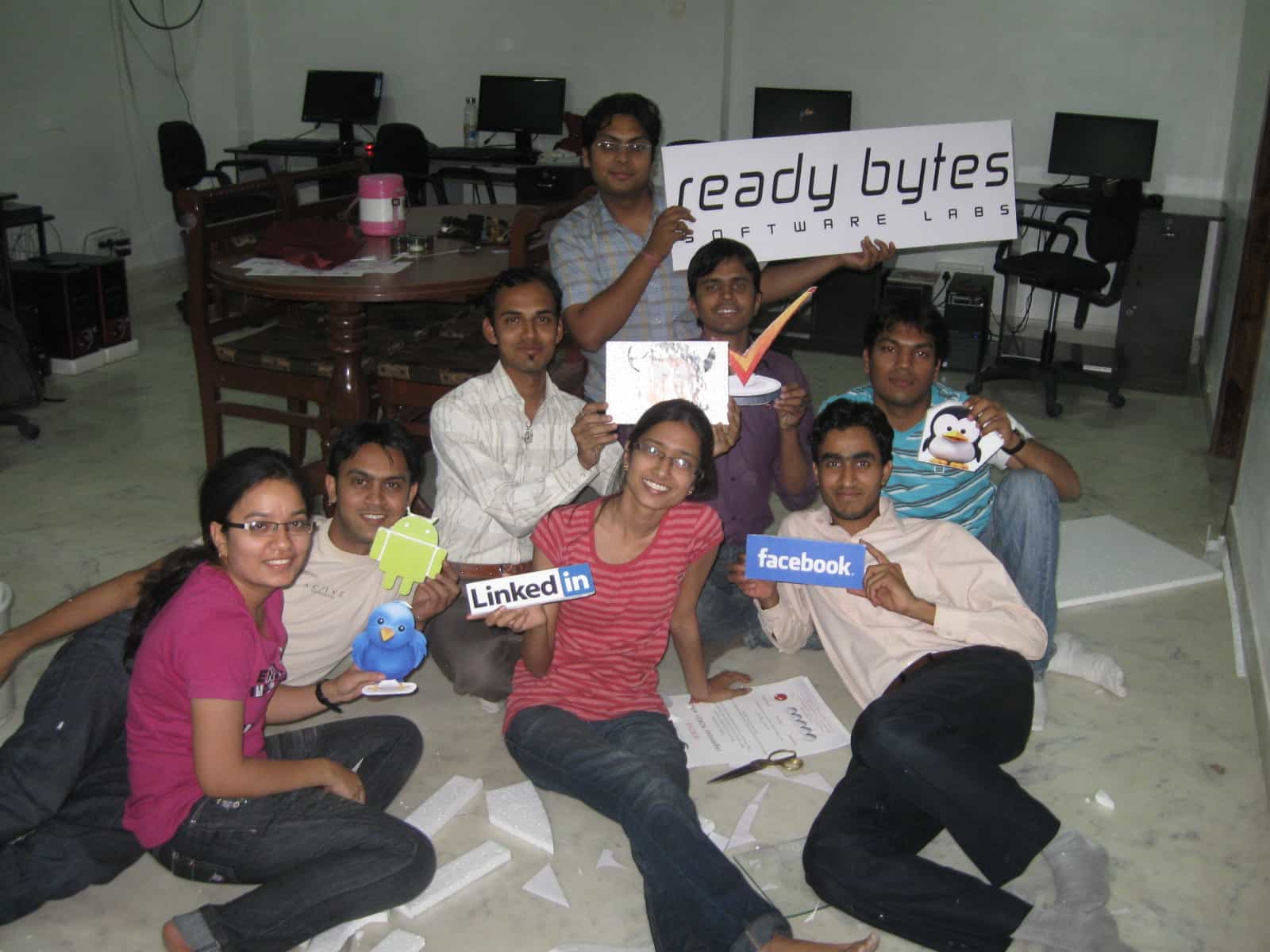 Early Ready Bytes team holding the company sign and tech logo cutouts in 2011